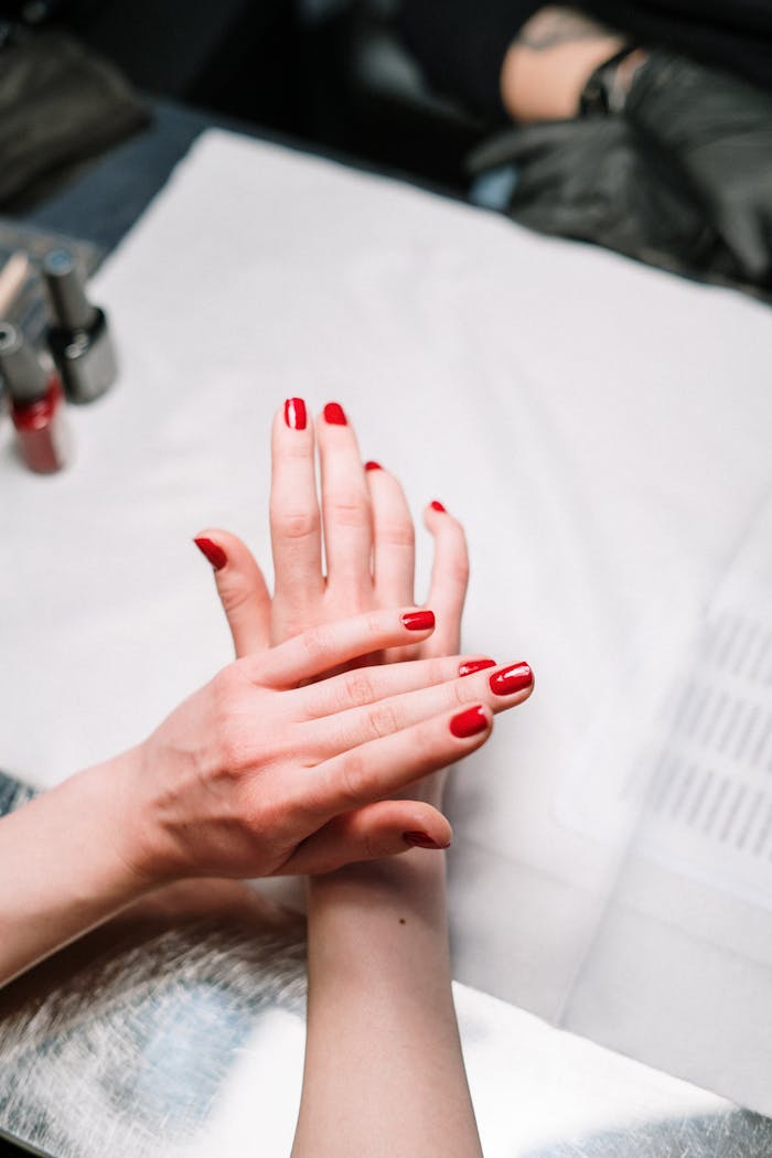 Services Professional hand treatment features a stylish red manicure at a modern nail salon.